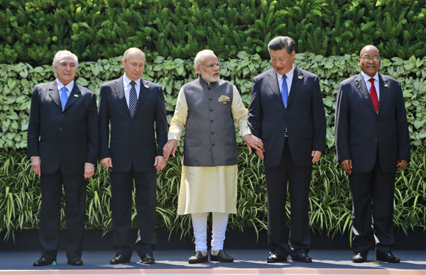 Leaders of BRICS countries (from left) Brazilian President Michel Temer, Russian President Vladimir Putin, Indian Prime Minister Narendra Modi, Chinese President Xi Jinping and South African President Jacob Zuma raise their hand for a group photo at the start of their summit in Goa, India, on Sunday (AP photo)